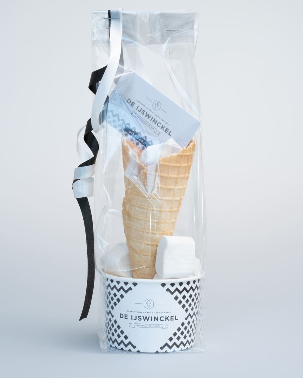 The luxury transparent gift package from De IJswinckel with an IJspas, cup, ice cream cone and marshmallows, finished with black-and-white ribbon
