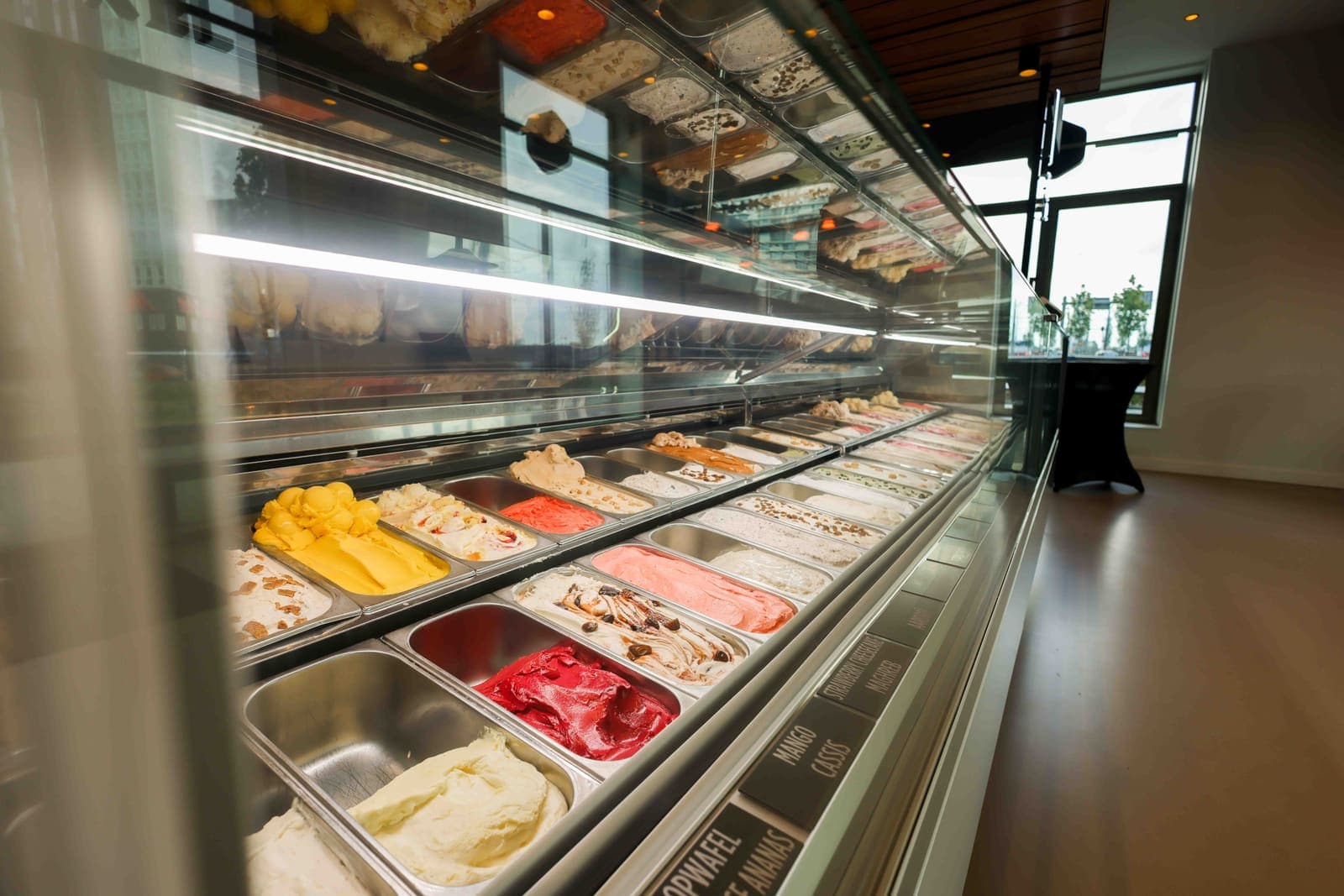 De ijsvitrine van De IJswinckel met een rij smaken